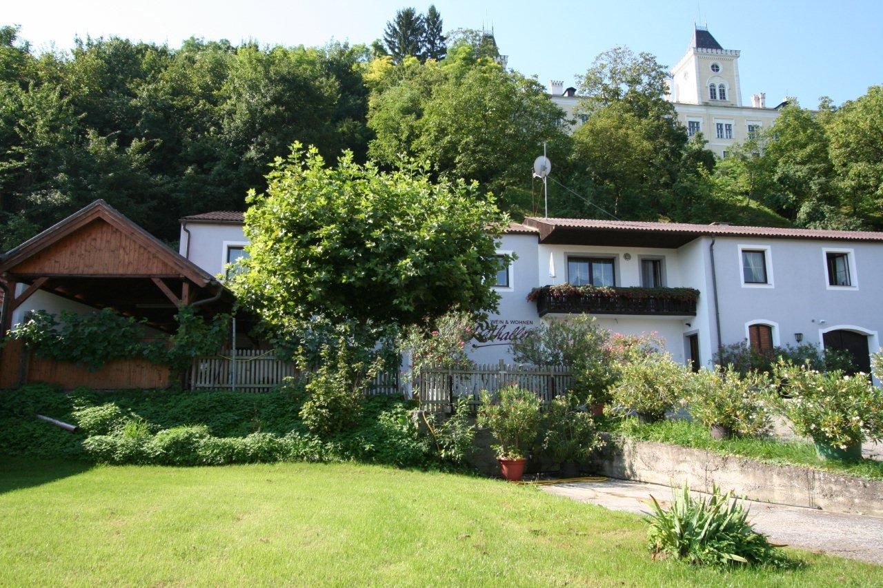 Außenansicht eines Hauses mit Garten und Bäumen im Hintergrund.