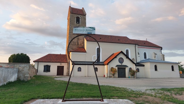 Kirche in Hohenwarth mit gro&szlig;em Schl&uuml;sselloch-Skulptur im Vordergrund.