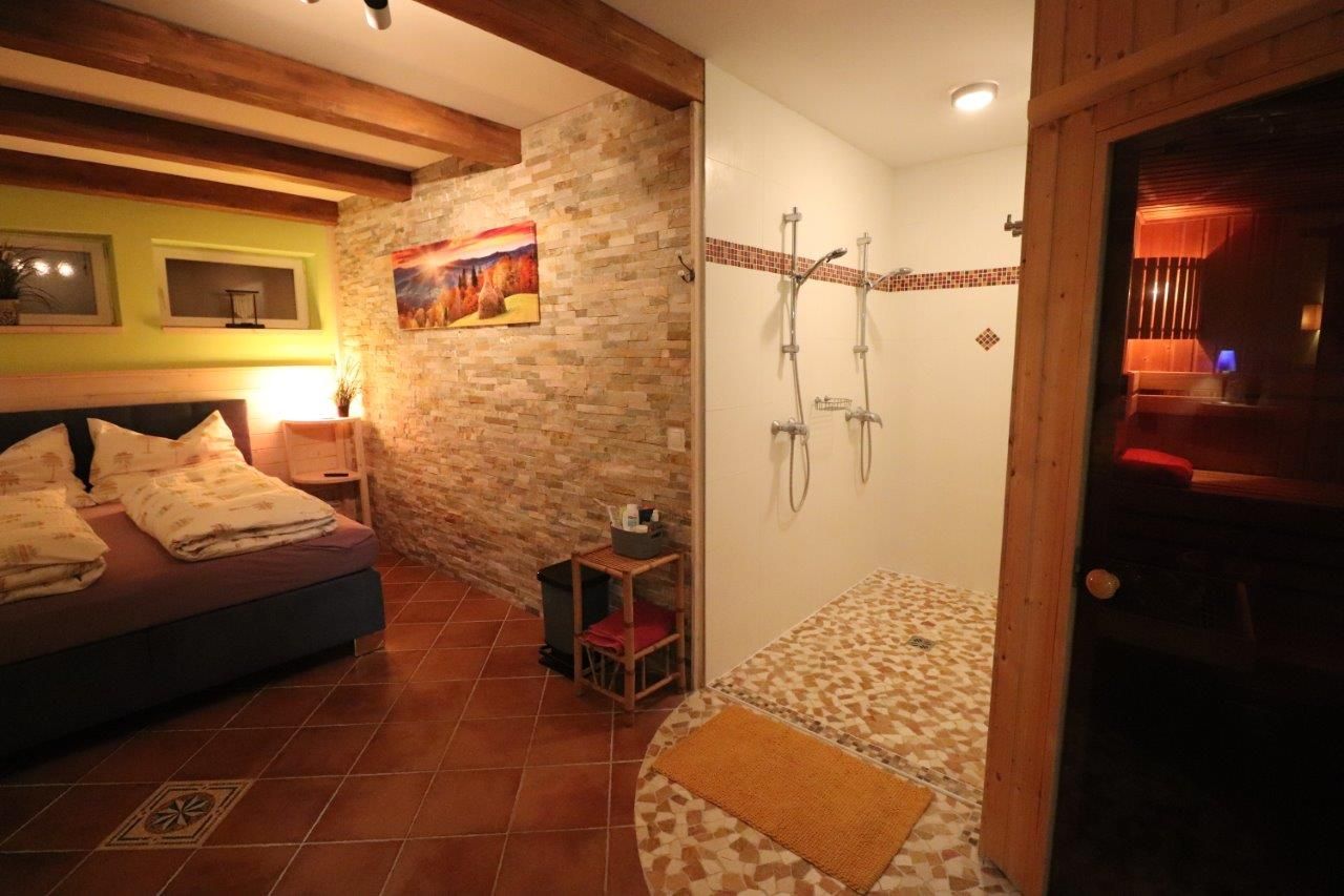 Gästezimmer mit Blick auf das Bett und zur Dusche 