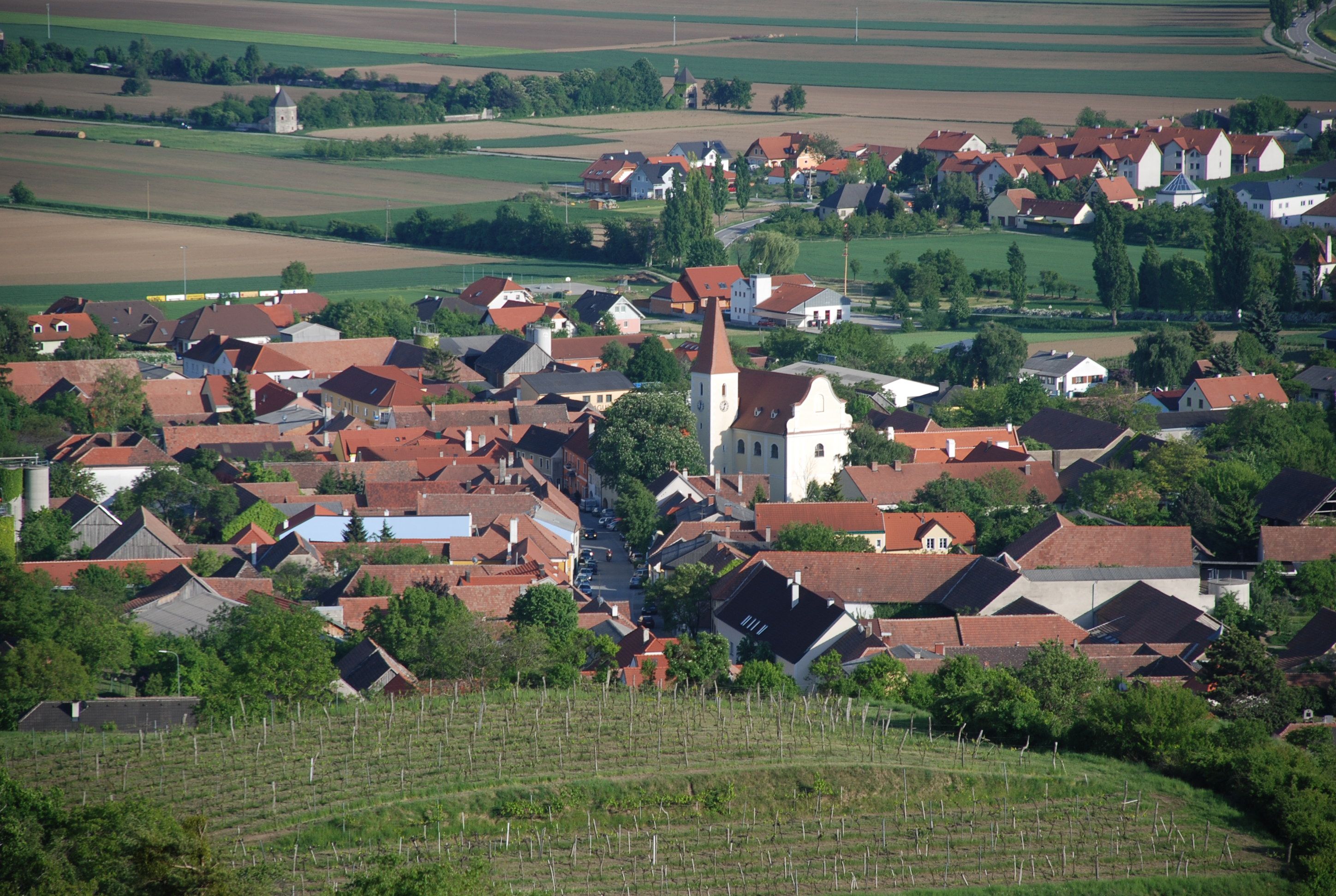 Luftaufnahme von Inzersdorf mit Pfarrkirche und umliegenden Häusern.