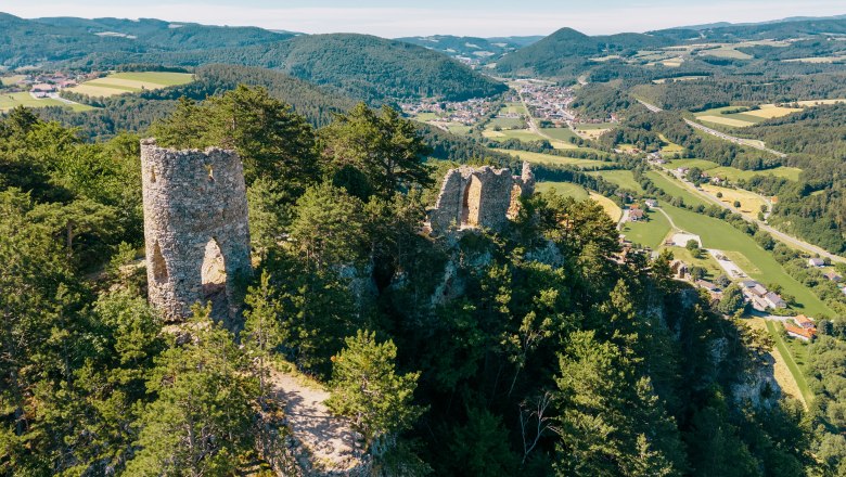 Luftaufnahme der Ruine Türkensturz inmitten von bewaldeten Hügeln und grünen Tälern.