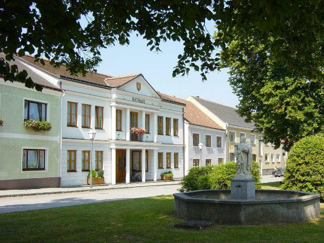 Rathaus von Schweiggers mit Brunnen im Vordergrund.