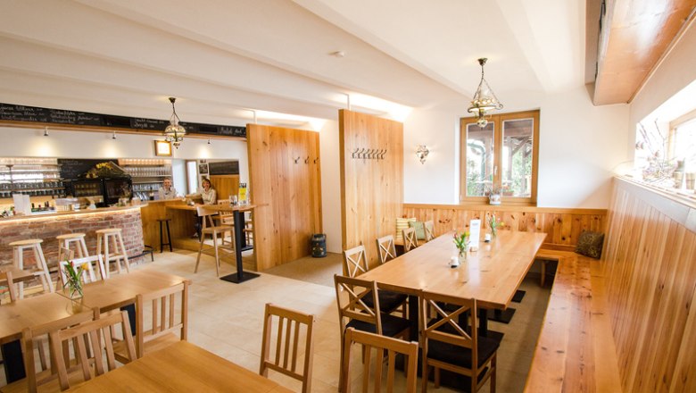 Gem&uuml;tlicher Gastraum mit Holzm&ouml;beln und Bar.