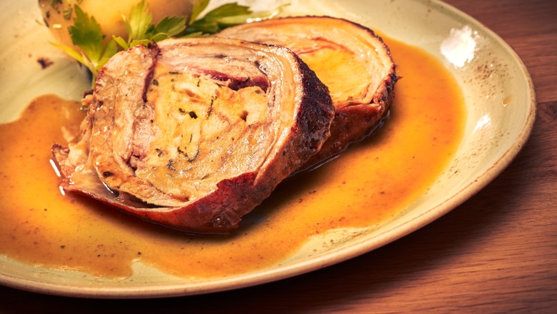 Ein Teller mit Braten und Kartoffel in Soße.