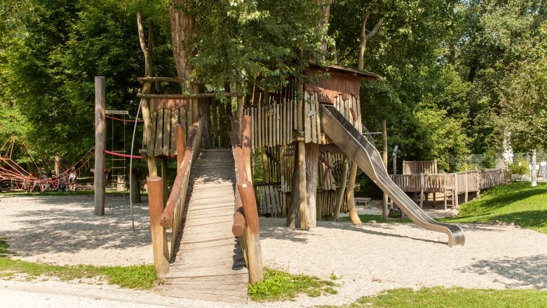 Abenteuer- und Naturspielplatz mit Holzbr&uuml;cke und Rutsche.