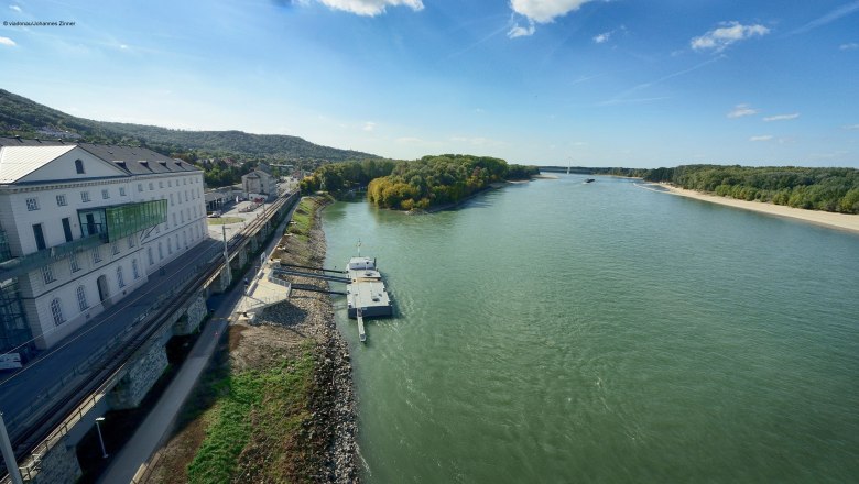 Blick auf die Donau bei Hainburg mit Anlegestelle und Geb&auml;uden am Ufer.