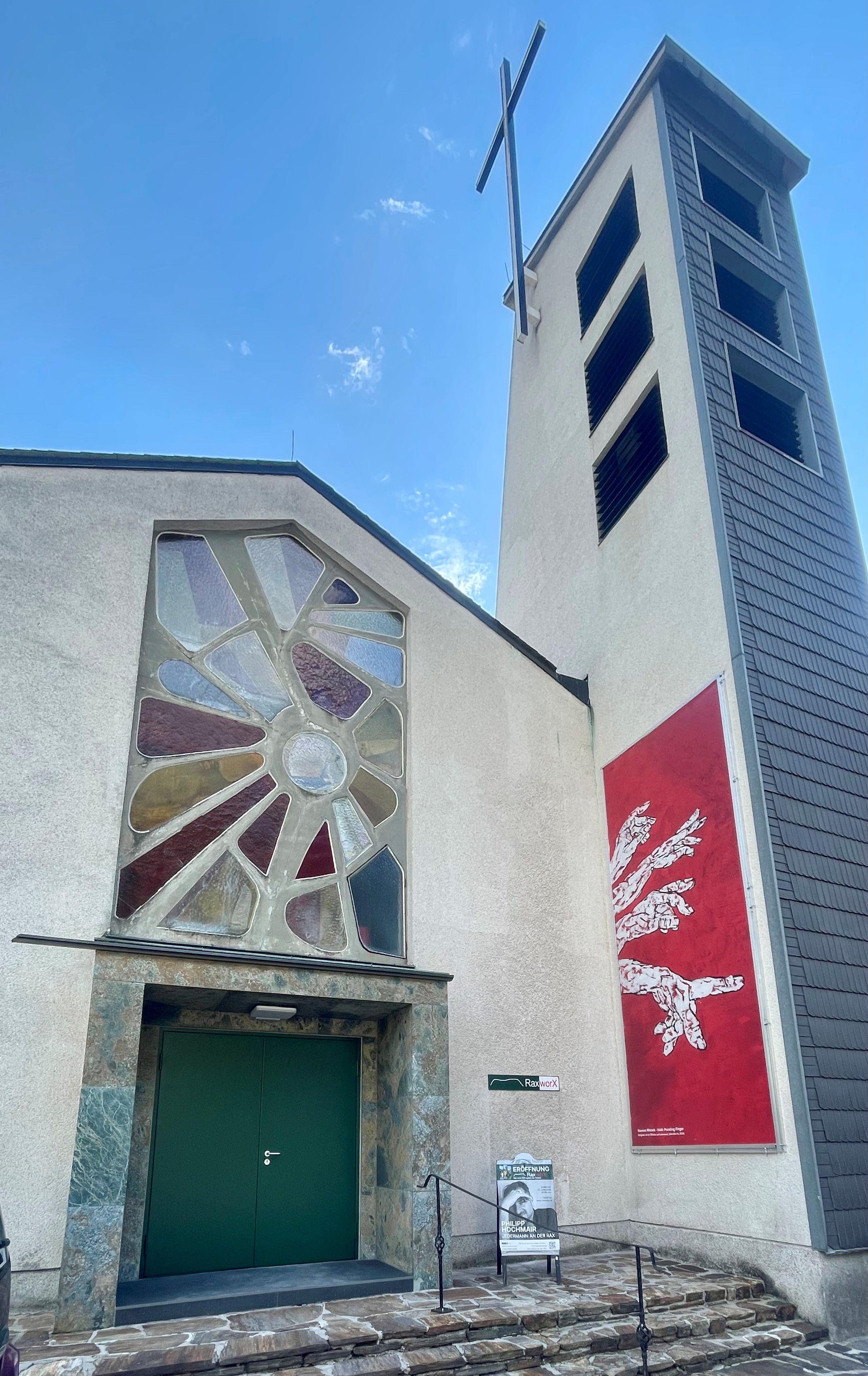 Ehemalige Kirche mit modernem Glasfenster und Glockenturm