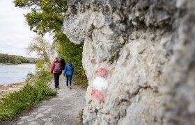 Zwei Frauen auf einem Wanderweg neben der Donau.