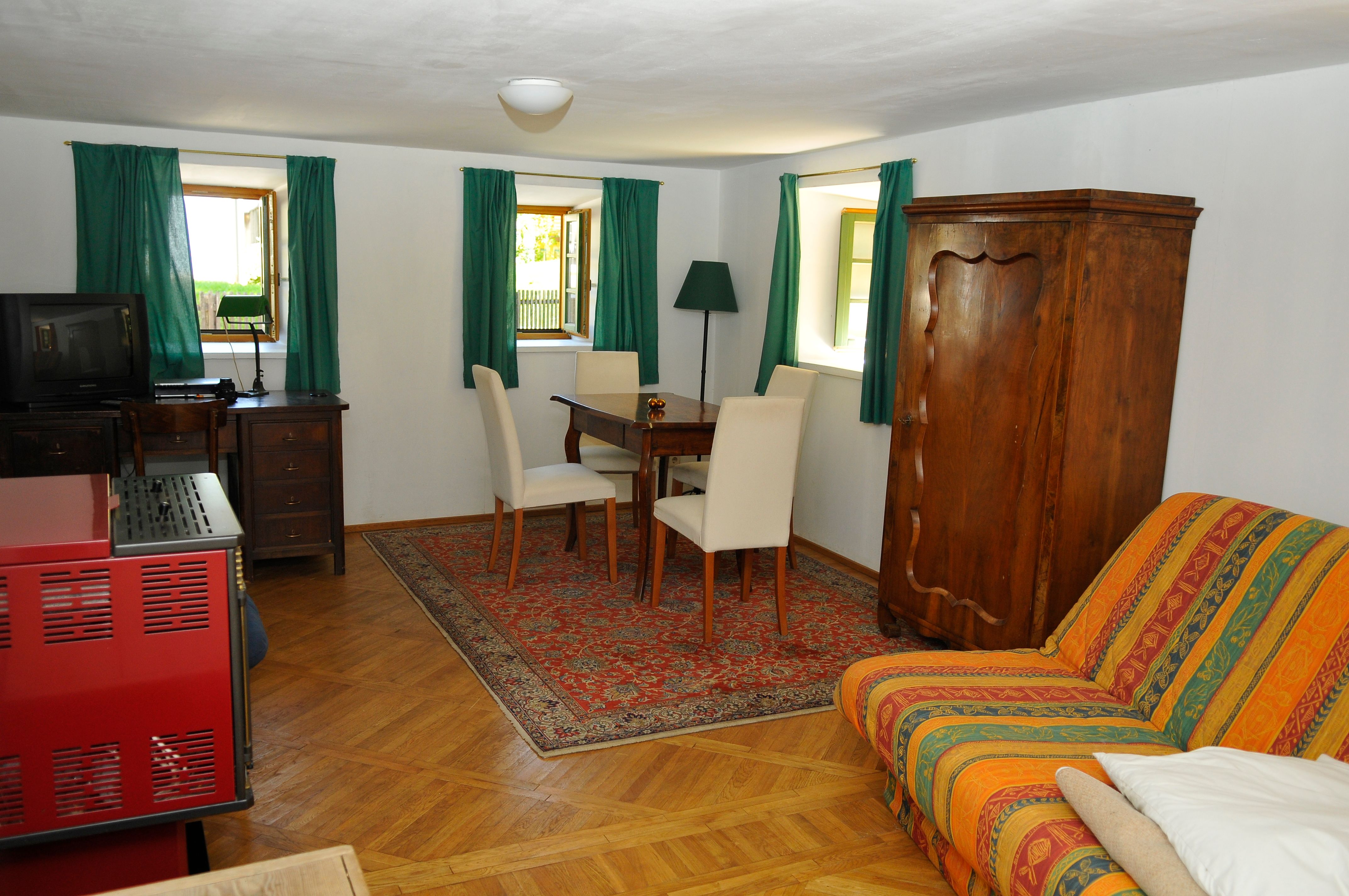 Gemütliches Gästezimmer mit Holzmöbeln, Teppich und Sofa.