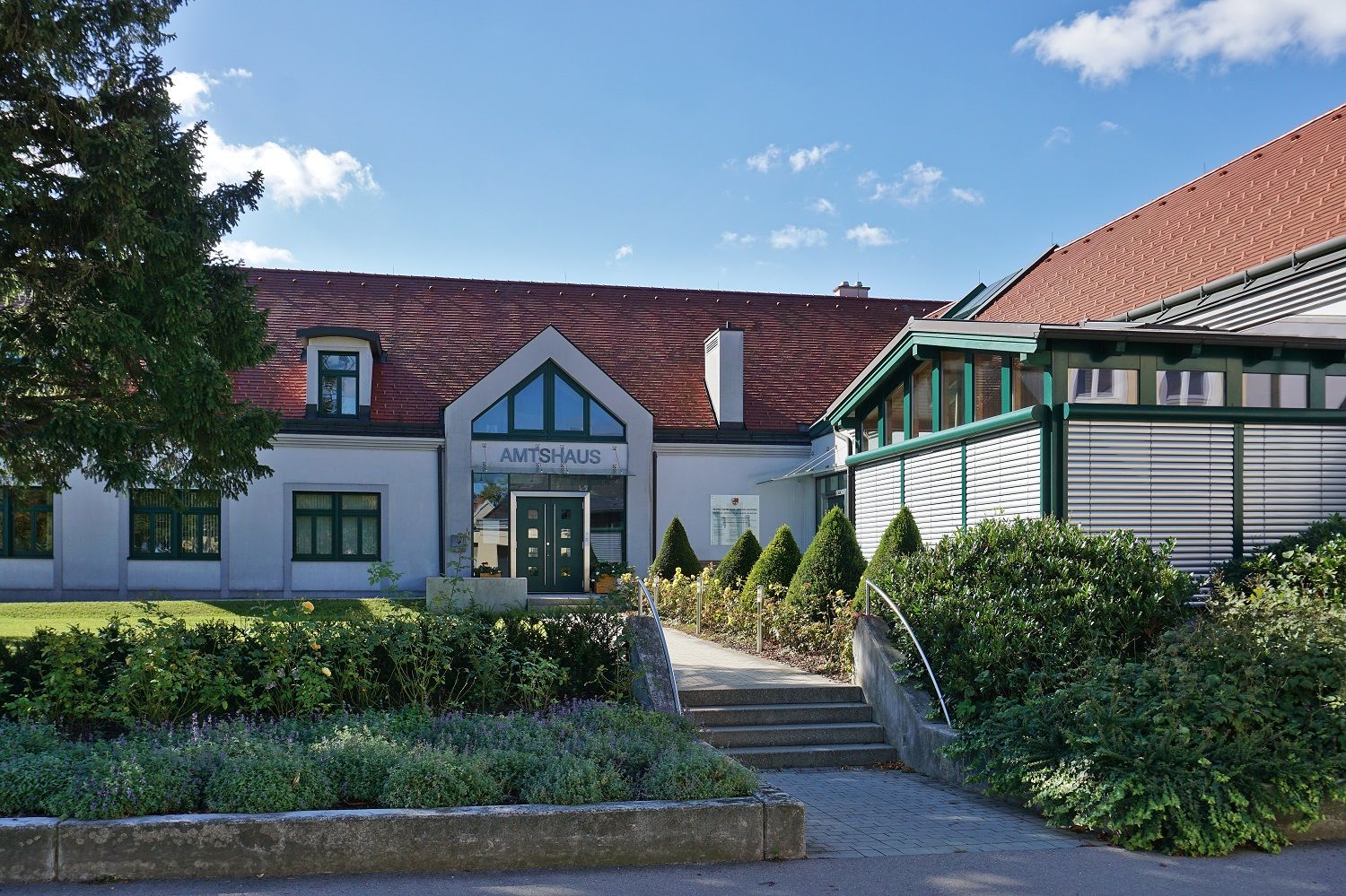 Amtsgebäude mit rotem Dach und Garten in Michelhausen.
