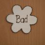 Holzschild in Blumenform mit der Aufschrift 'Bad'.