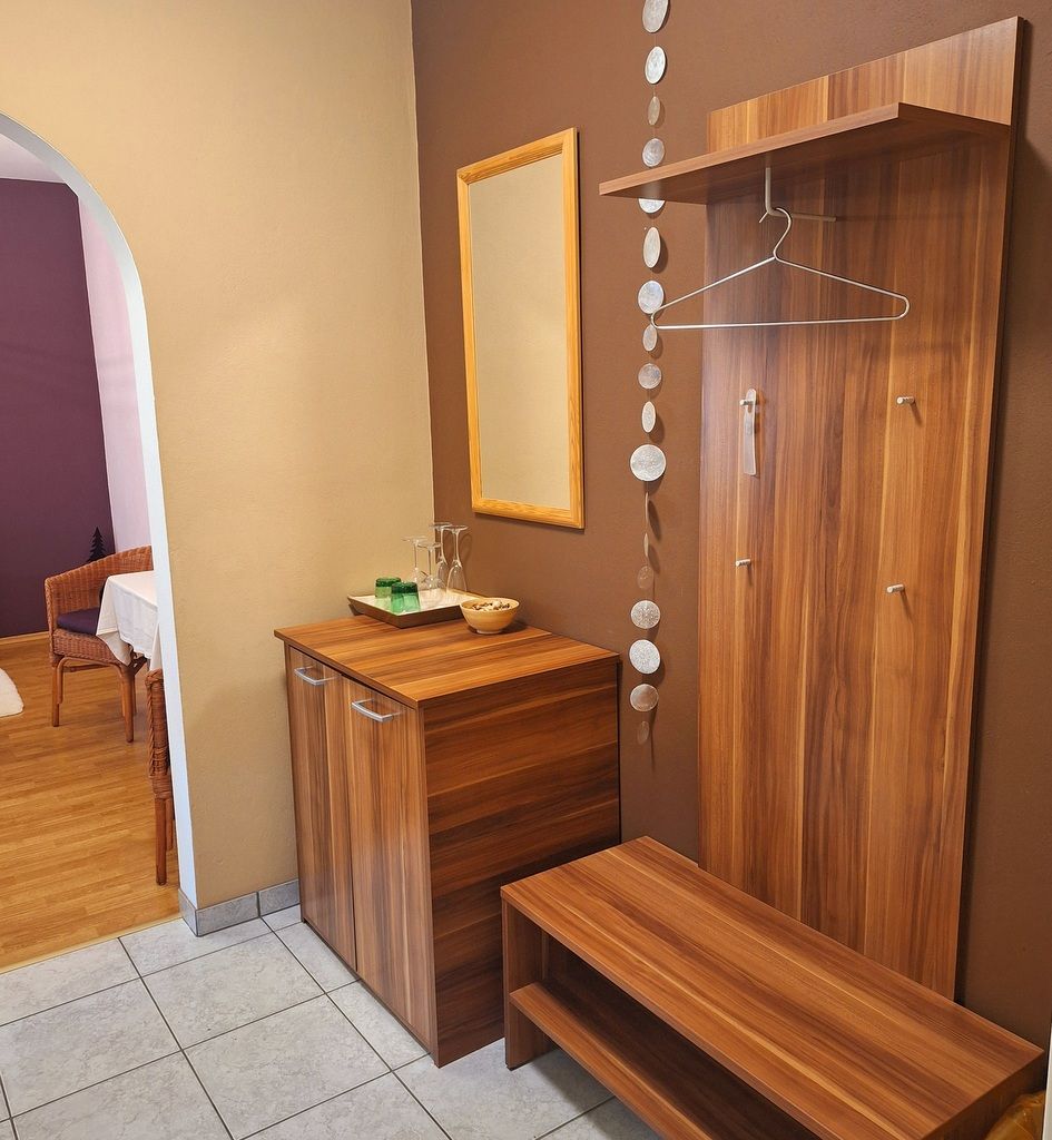 Moderner Eingangsbereich mit Holzmöbeln, Spiegel und Dekoration.