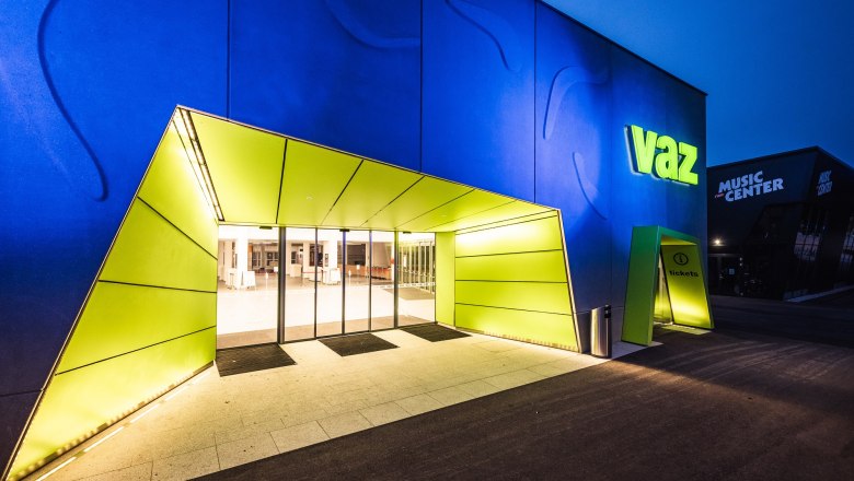 Eingang des VAZ St. P&ouml;lten mit beleuchtetem Schild und moderner Architektur.