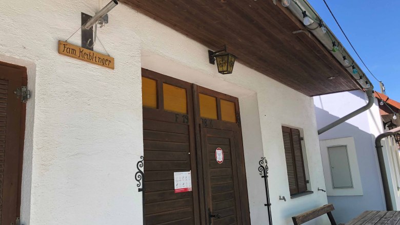 Eingang eines Heurigenlokals mit Holzschild 'Fam. Keiblinger'.