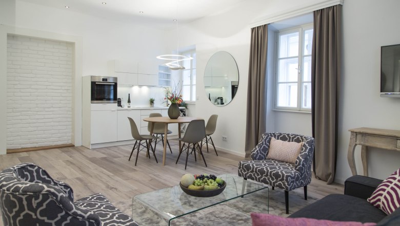 Modernes Wohnzimmer mit Küche, Esstisch und stilvollen Möbeln.