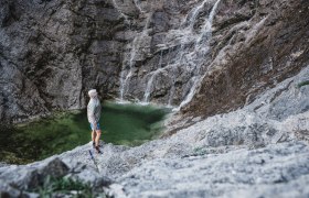 Wasser stürzt bei Felsen hinab.