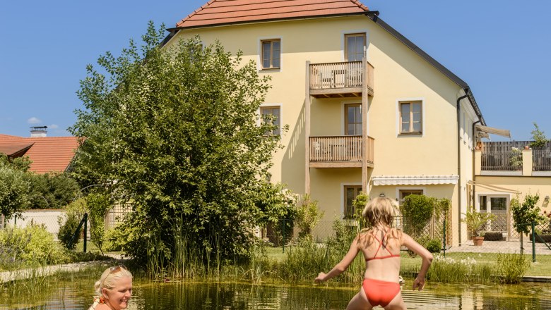 Eine Frau und zwei Kinder am Badeteich im ad vineas Gästehaus