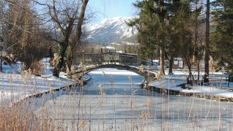 Verschneite Landschaft mit gefrorenem Fluss und Br&uuml;cke in Reichenau.