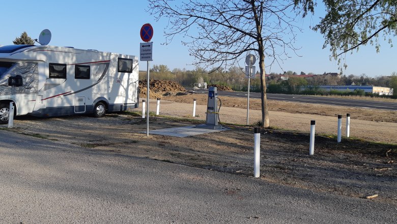 Wohnmobilstellplatz, © Stadtgemeinde Hollabrunn Wohnmobil auf einem Stellplatz mit Schildern und Bäumen.