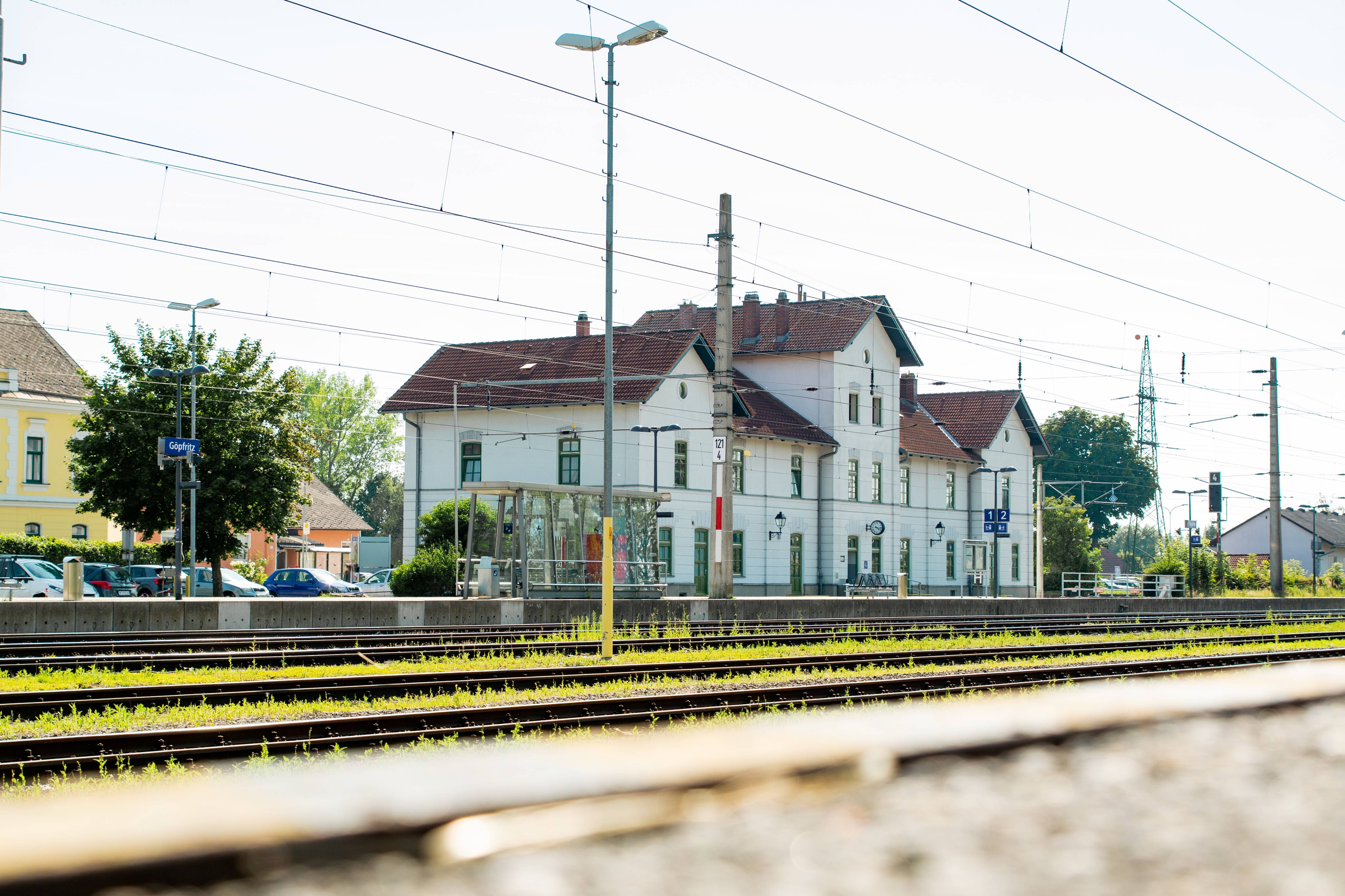 Schienen vor einem weißen Bahnhofshaus