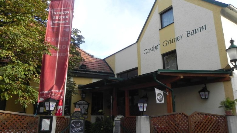 Eingang des Gasthofs Grüner Baum mit rotem Banner und Willkommensschild.