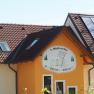 Geb&auml;ude mit Schild '1. Waldviertler Kinderbauernhof', Solarpanelen auf dem Dach.
