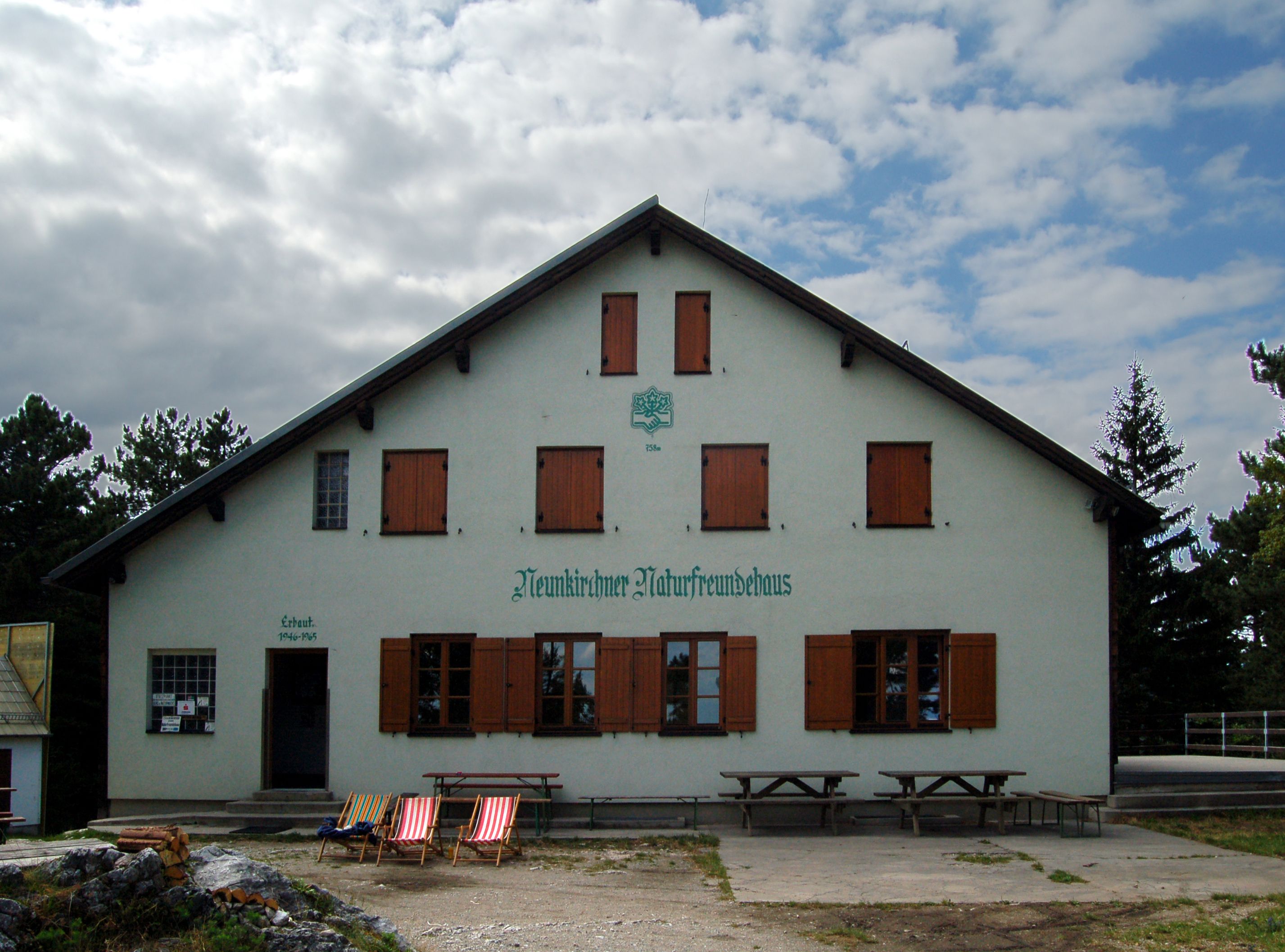 Neunkirchner Naturfreundehaus mit Liegestühlen davor.