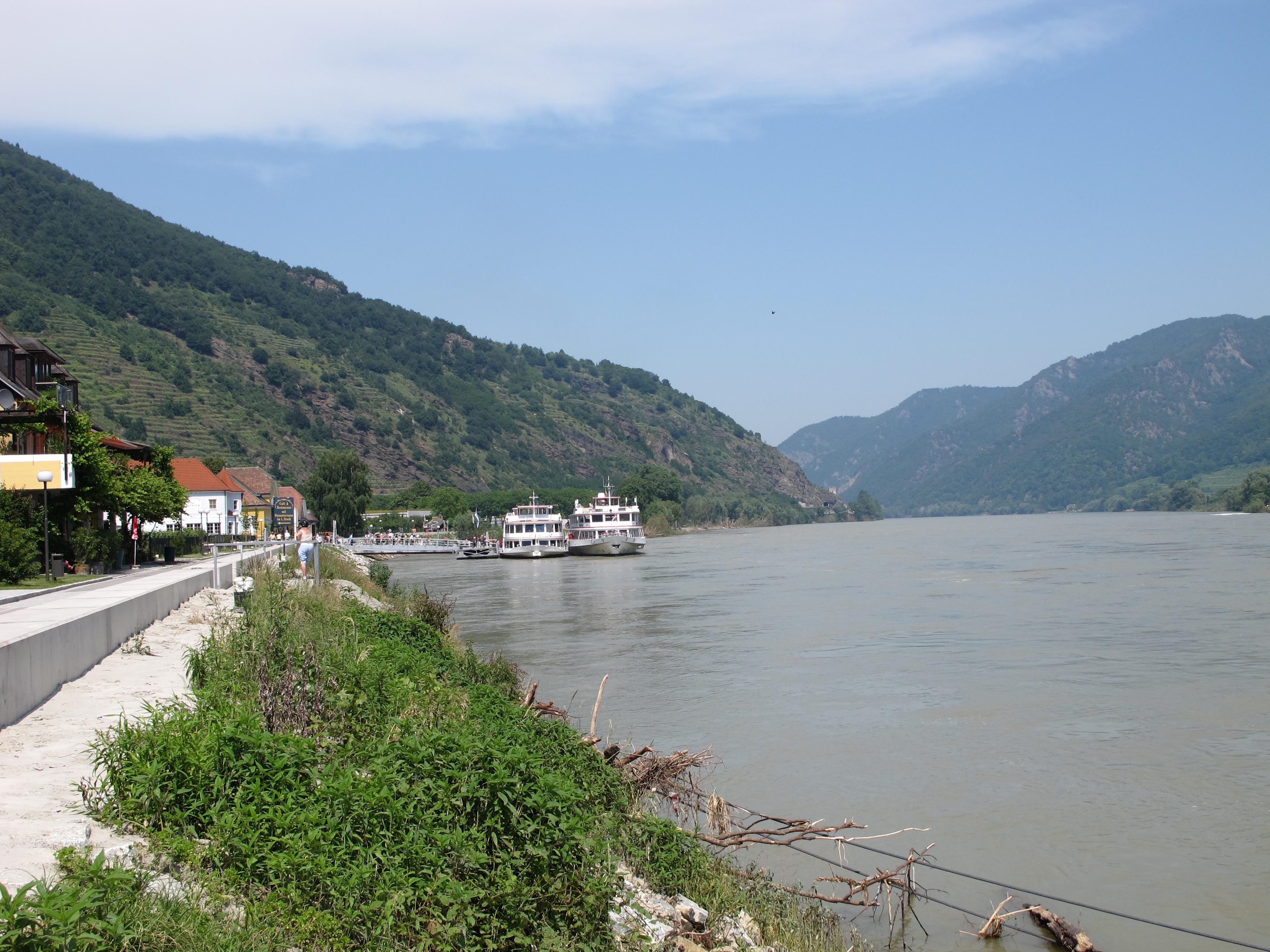 Anlegestelle in Spitz an der Donau mit Schiffen und Hügeln im Hintergrund.