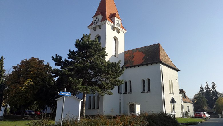 Pfarr- und Wallfahrtskirche Dro&szlig; mit rotem Dach und Uhrturm.
