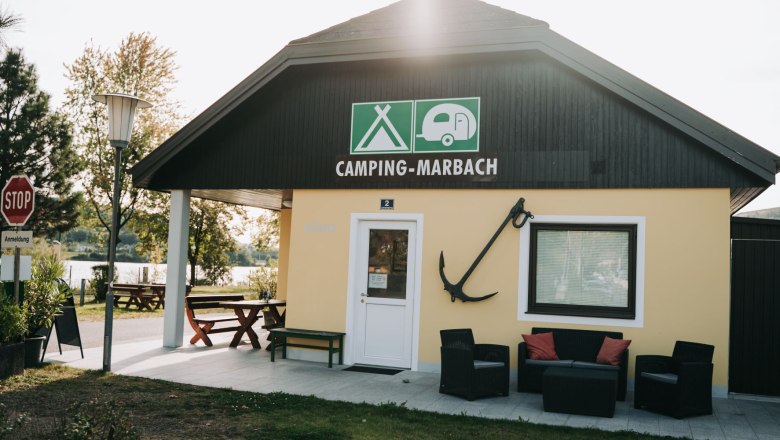 Eingangsbereich des Campingplatzes Marbach mit Sitzgelegenheiten und einem Anker an der Wand.