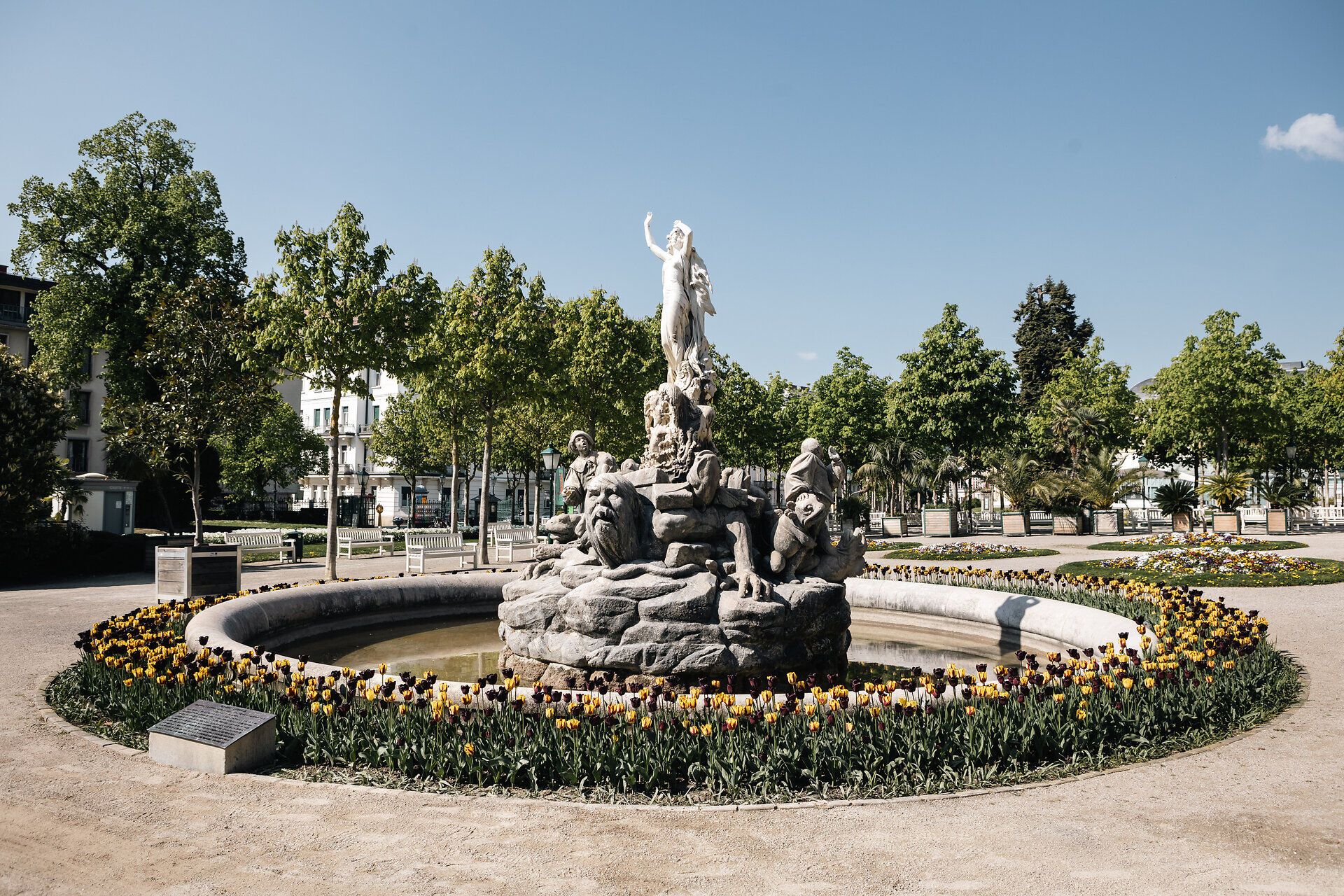 Der Undinebrunnen im Kurpark Baden strahlt eine friedliche Atmosphäre aus, umgeben von üppigem Grün und bunten Tulpenbeeten. Die majestätische Statue, die die Wasserfee darstellt, lädt Besucher ein, einen Moment der Ruhe und Besinnung zu genießen. Hier, wo Natur und Kunst harmonisch verschmelzen, wird jeder Spaziergang zu einem unvergesslichen Erlebnis.