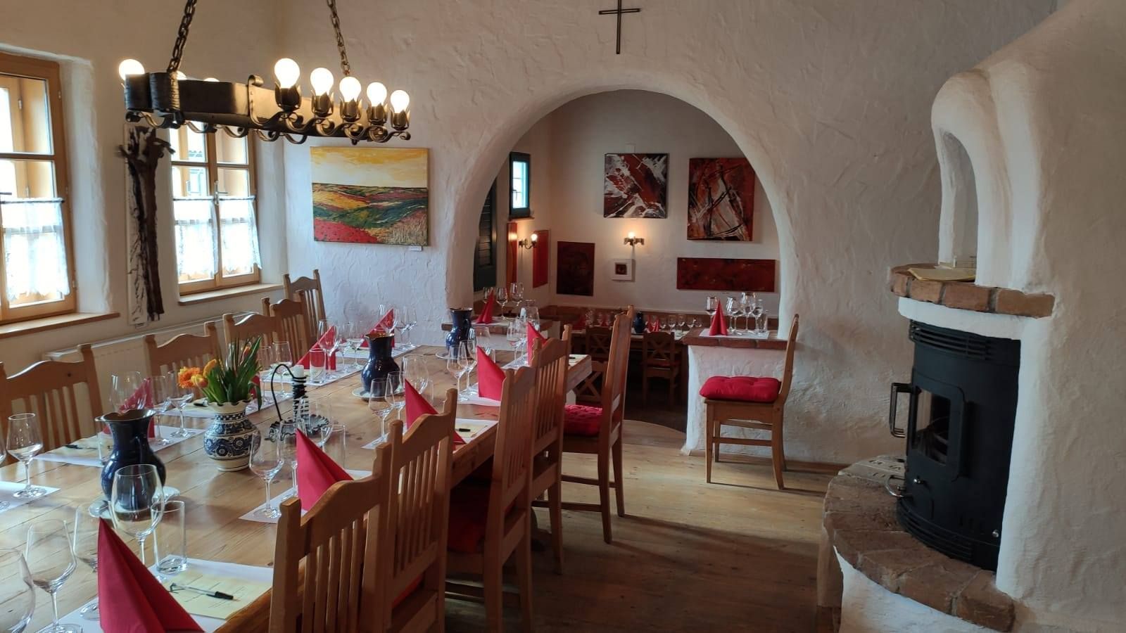 Gemütlicher Raum mit gedecktem Tisch, Weingläsern und Kamin.