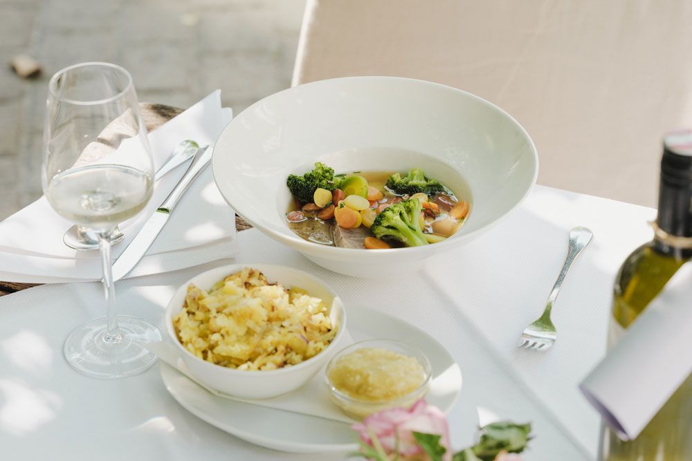 Elegantes Gericht mit Fleisch, Gemüse, Kartoffeln und Weißwein.