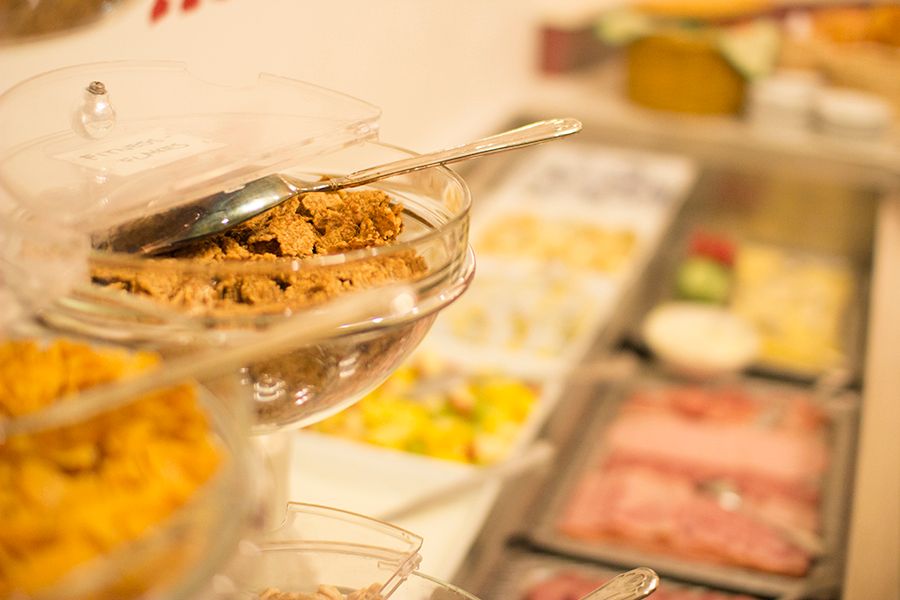 Ein Frühstücksbüffet mit Müsli, Aufschnitt und Obst.