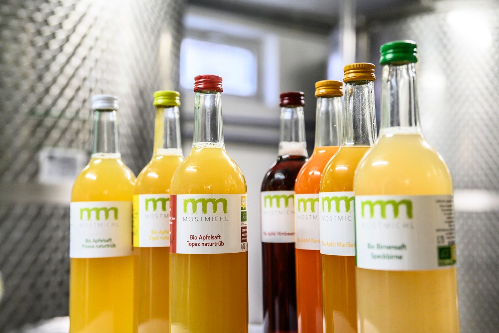 Flaschen mit verschiedenen Bio-Säften von MostMichl in einem Regal.