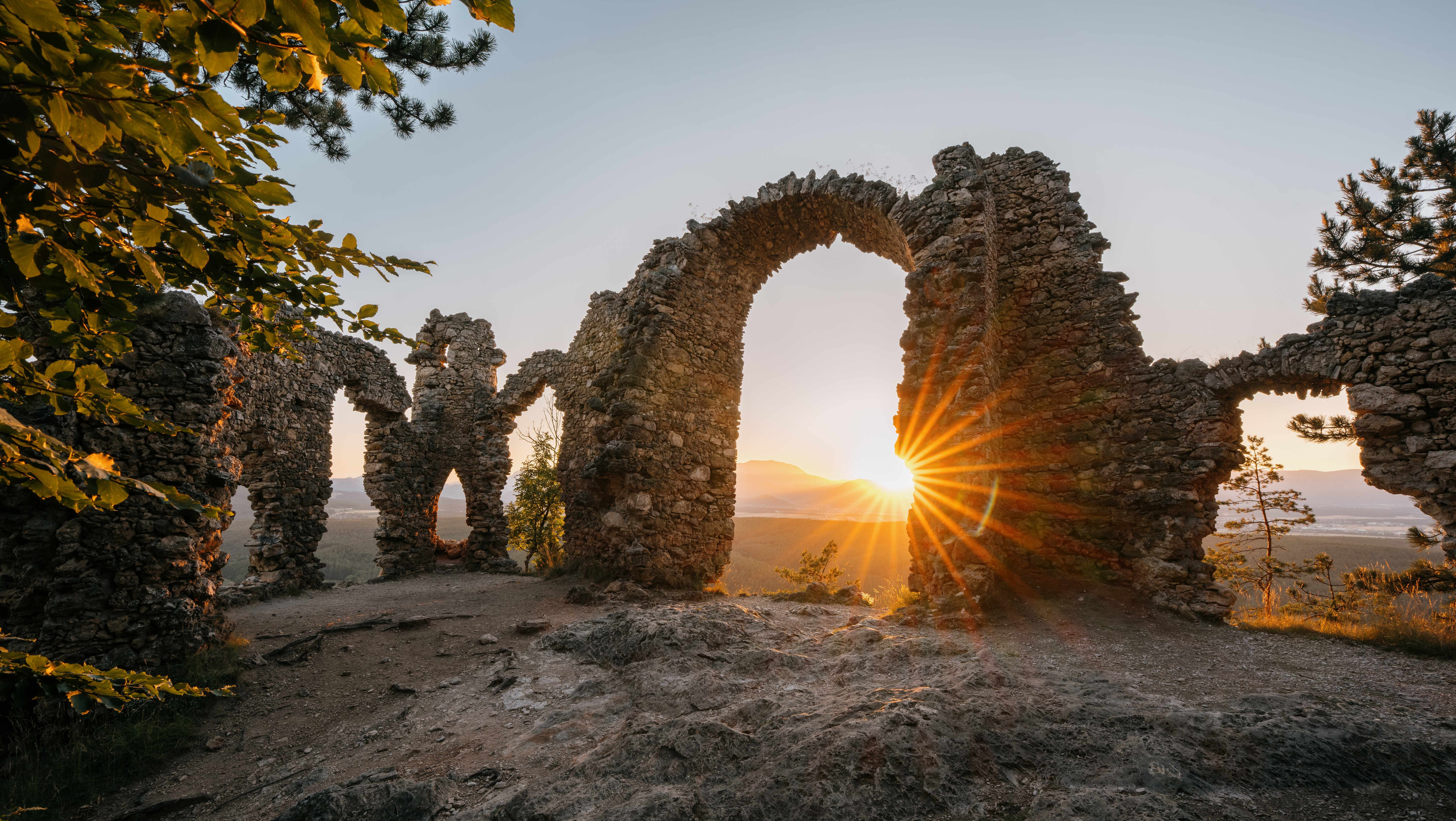 Ruine Türkensturz bei Sonnenuntergang mit Sonnenstrahlen durch die steinernen Bögen.