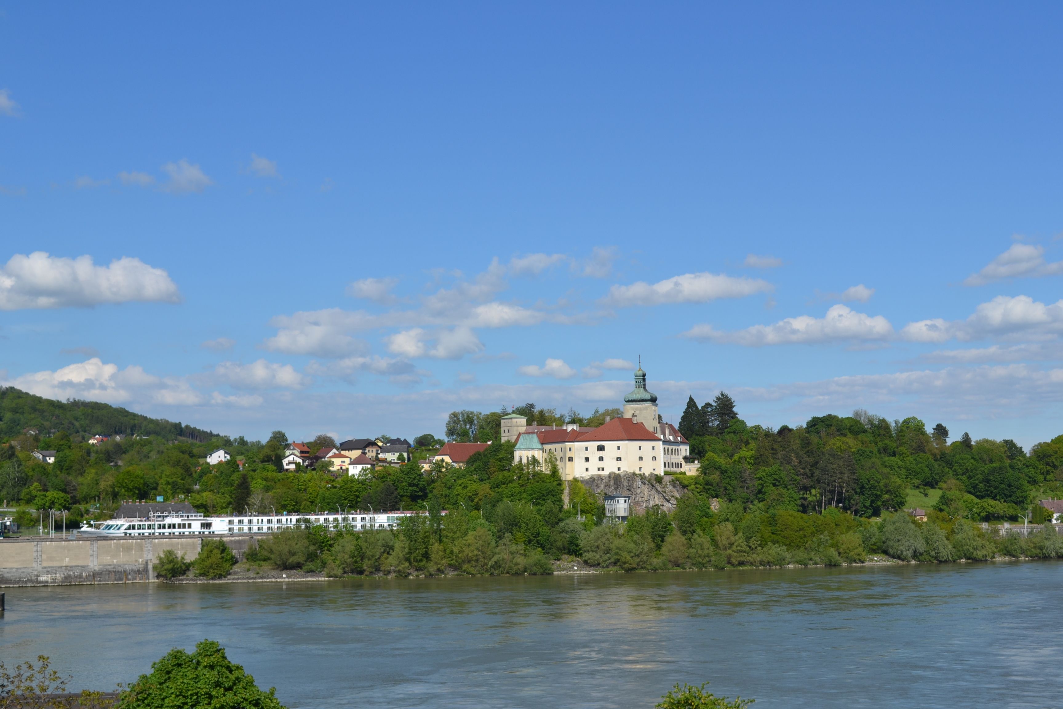 Schloss Persenbeug und Umgebung an einem sonnigen Tag mit blauem Himmel.