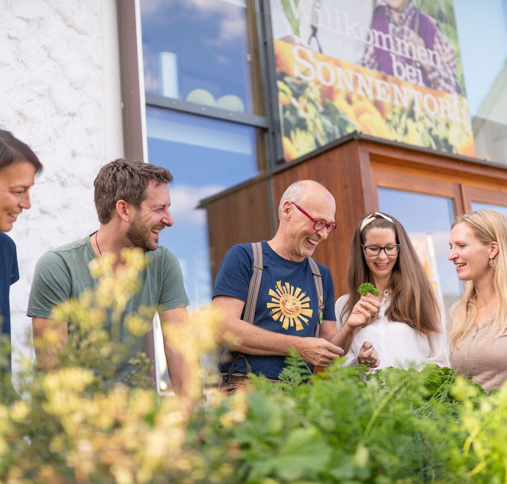 Inmitten der duftenden Kräuter und frischen Pflanzen versammeln sich die Besucher, um mehr über die Kunst der Teezubereitung zu erfahren. Die strahlenden Gesichter und die lebhafte Atmosphäre laden dazu ein, die Natur in ihrer vollen Pracht zu genießen.