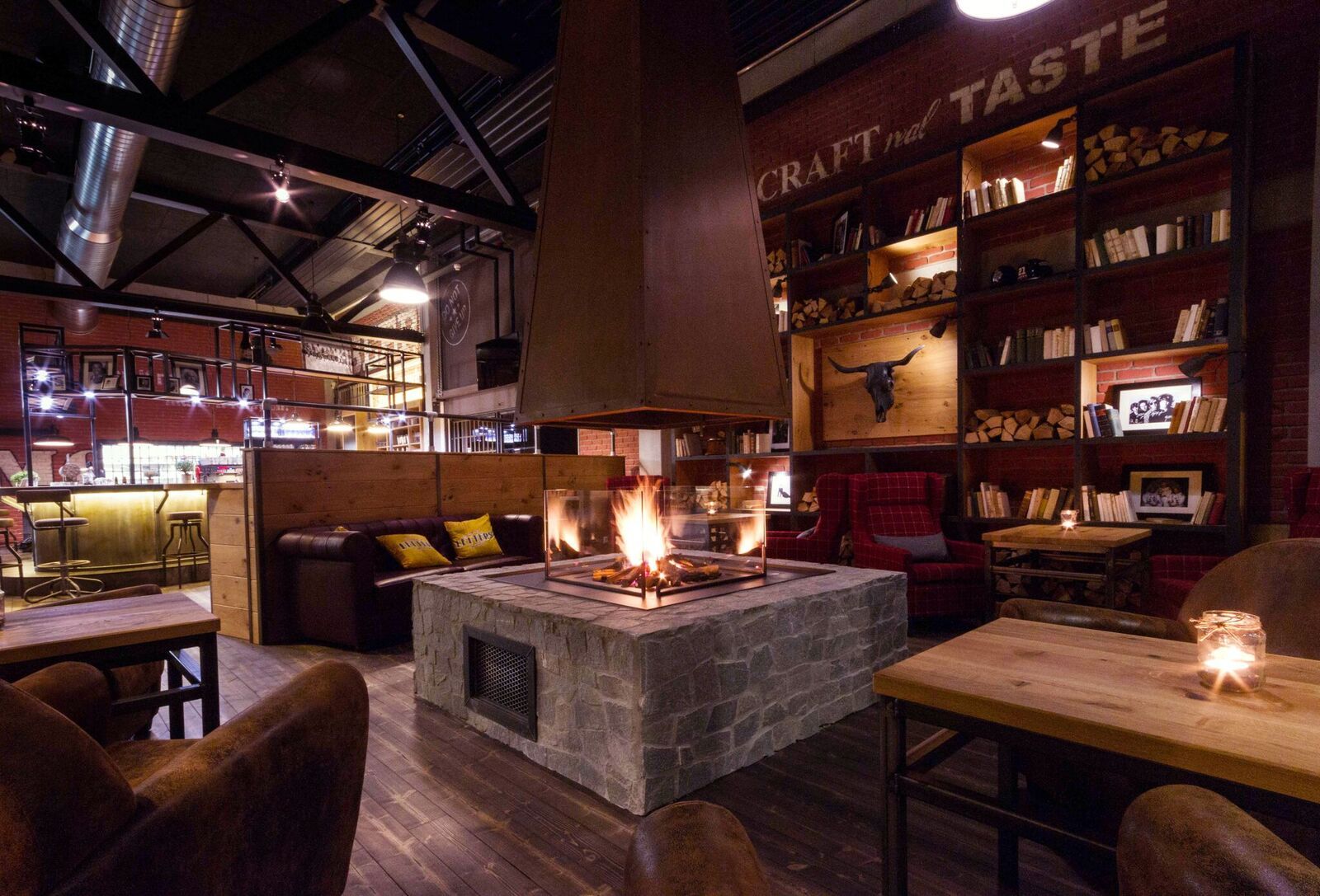 Gemütlicher Raum mit Kamin, Holzmöbeln und Bücherregalen.