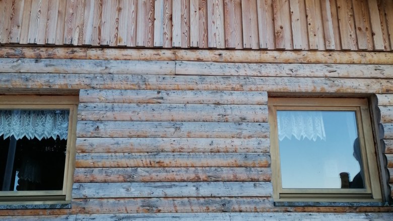 Holzhütte mit der Aufschrift 'Sumpihittn #2' über den Fenstern.