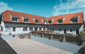 Ein Gebäude mit roten Dachziegeln und mehreren Dachfenstern, beschriftet mit 'Hubertushof'.