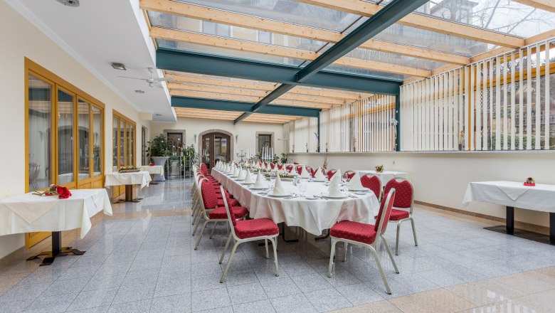 Waldviertler-Hof Wintergarten, © Waldviertler-Hof Eleganter Wintergarten mit gedecktem Tisch und roten Stühlen.