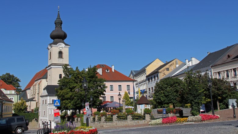 Stadtplatz in Heidenreichstein mit Kirche und bunten Blumenbeeten.