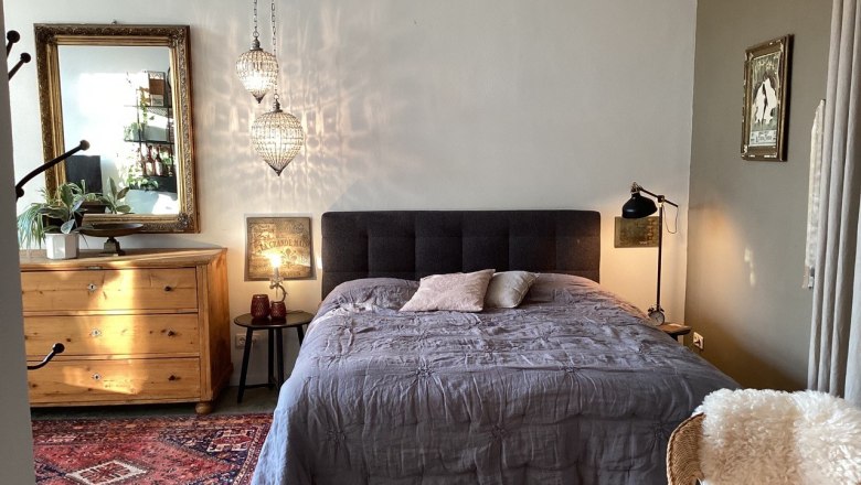 Gem&uuml;tliches Schlafzimmer mit Doppelbett, Holzm&ouml;beln und orientalischem Teppich.