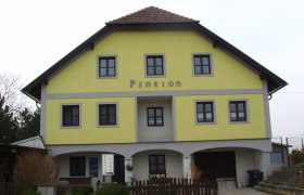 Gelbes Gebäude mit der Aufschrift 'Pension'.