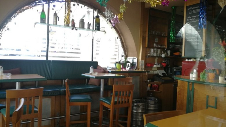 Innenansicht eines gemütlichen Cafés mit Dekorationen und Sitzgelegenheiten.