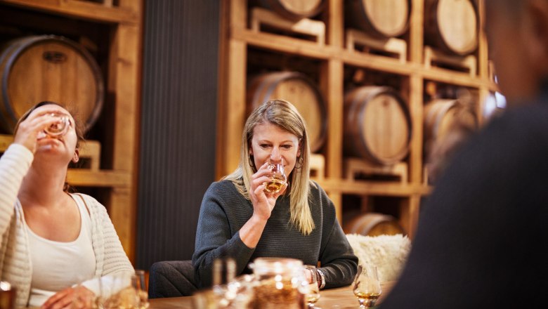 Personen bei einer Whisky-Verkostung in einer Destillerie.