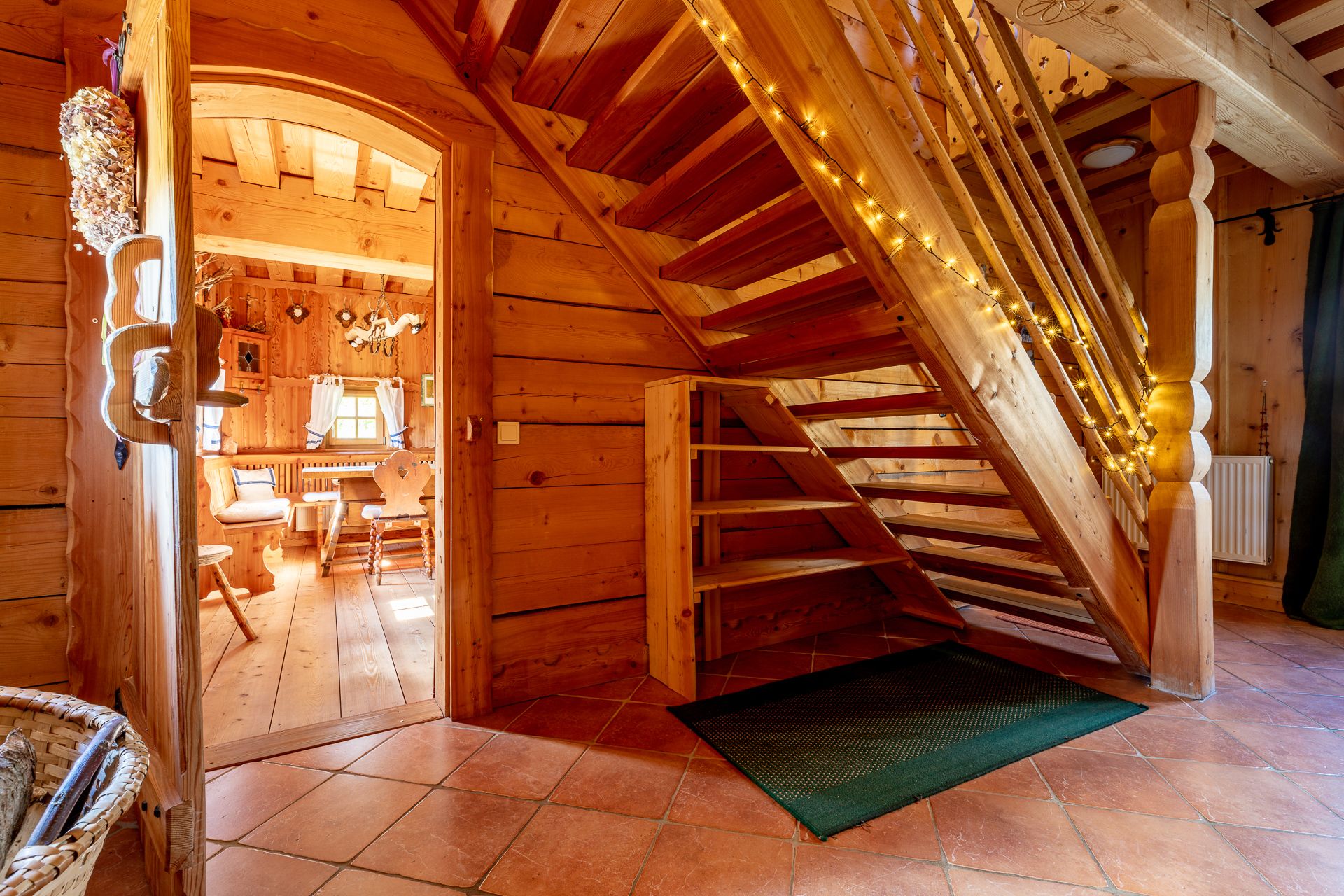 Holztreppe in einem Haum mit Holzvertäfelung mit Lichterkette dekoriert.