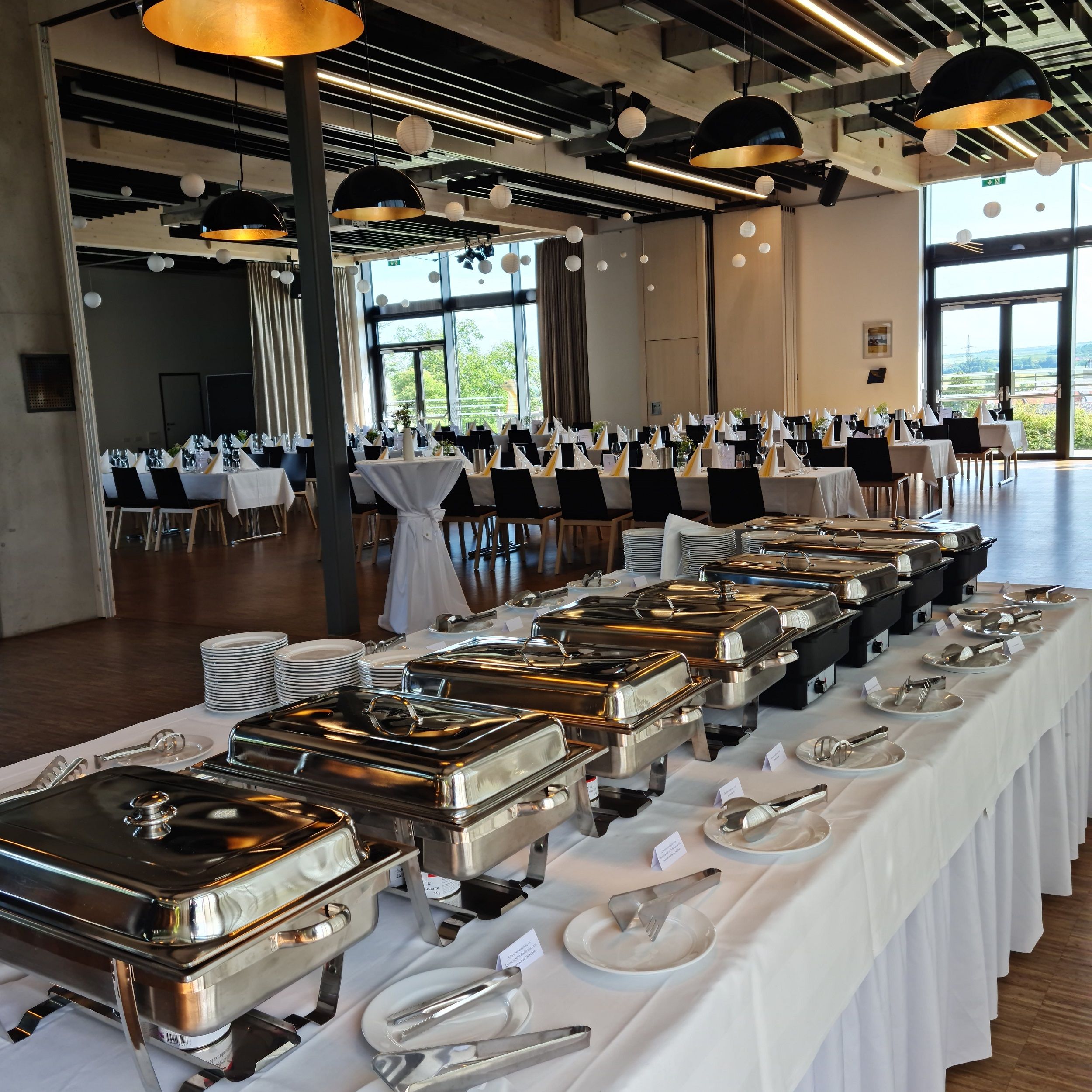 Ein festlich gedeckter Raum mit Buffet und gedeckten Tischen.