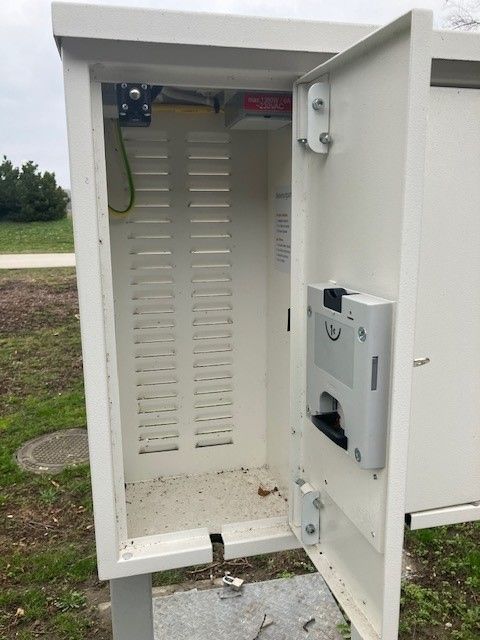 Offene E-Bike Ladestation im Freien mit leerem Innenraum.